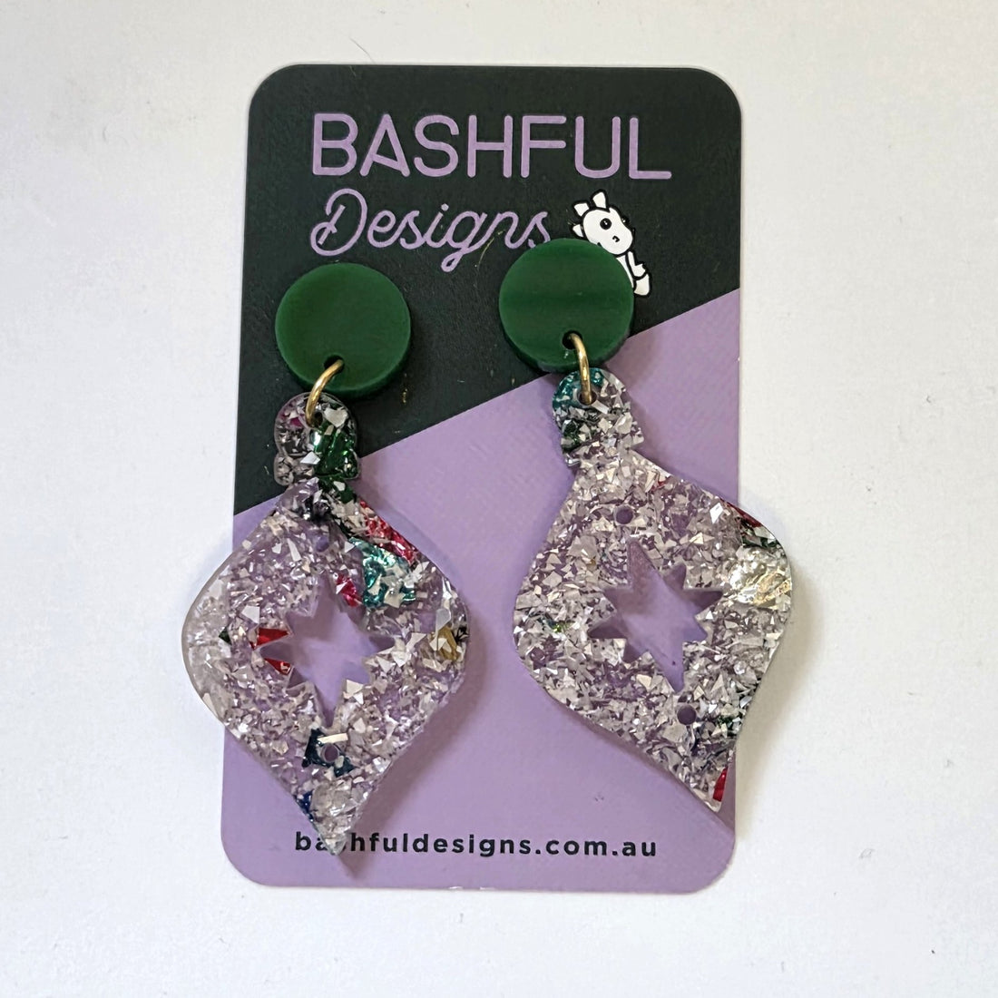 Earrings in the shape of a Christmas Tree bauble.  The earrings begin with a dark green acrylic topper, then flow into a bauble shape in silvery chunky glitter acrylic. 