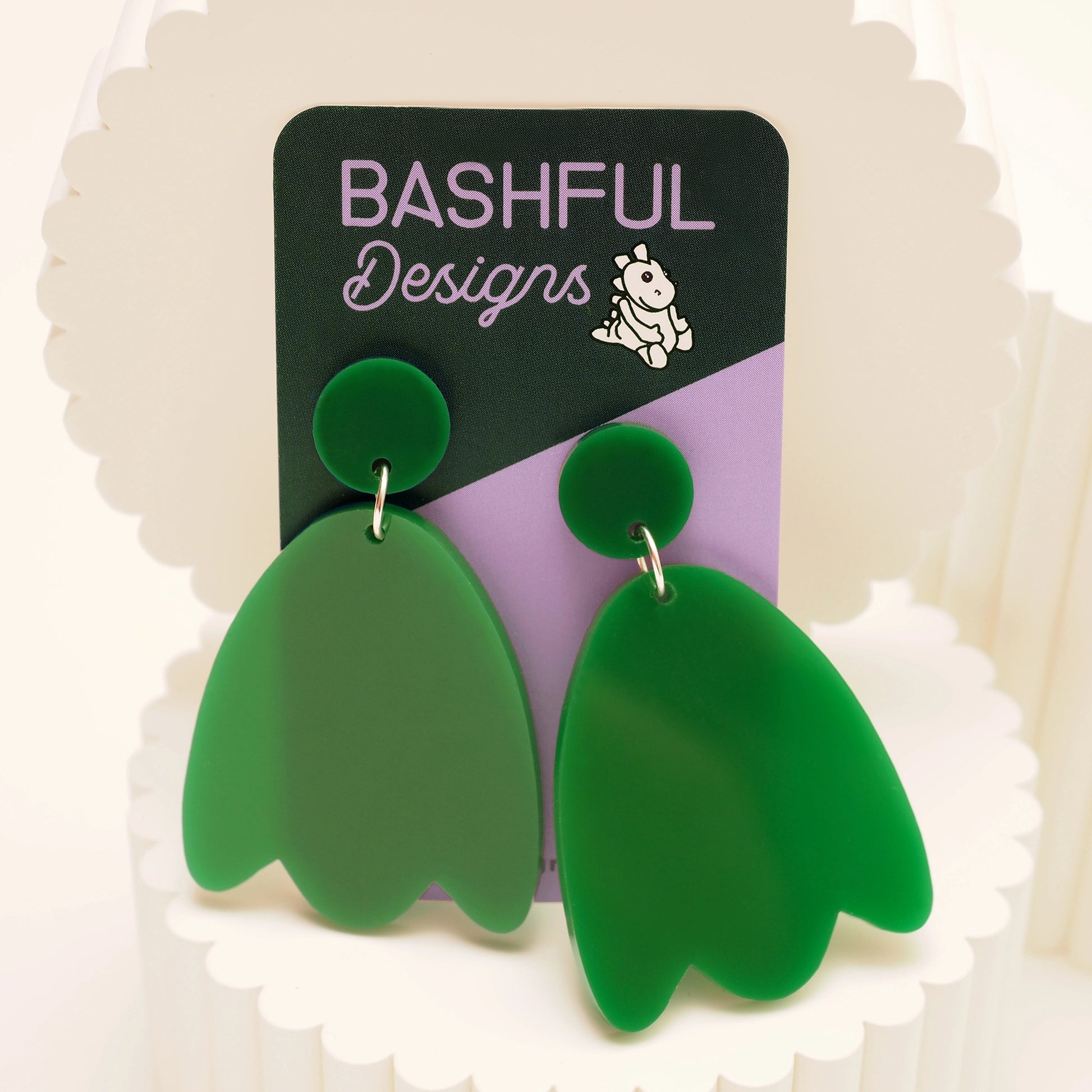 Solid green acrylic petal-shaped earrings. They also feature a solid green earring topper, and are shown on a 'Bashful Designs' earring card.