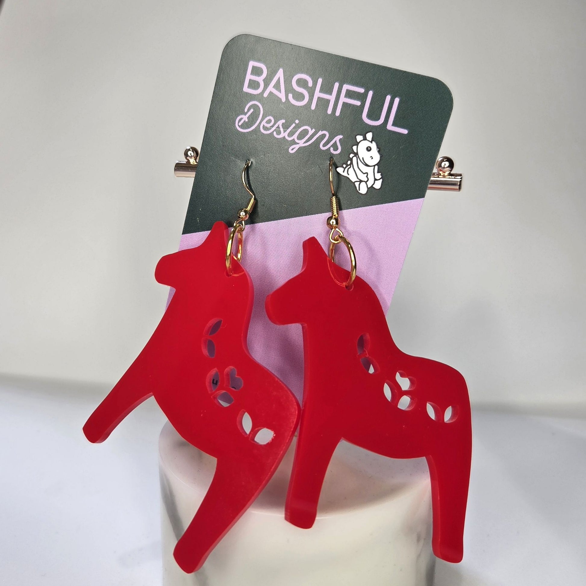 Earrings in a shape of a Nordic Christmas horse, made in red acrylic.