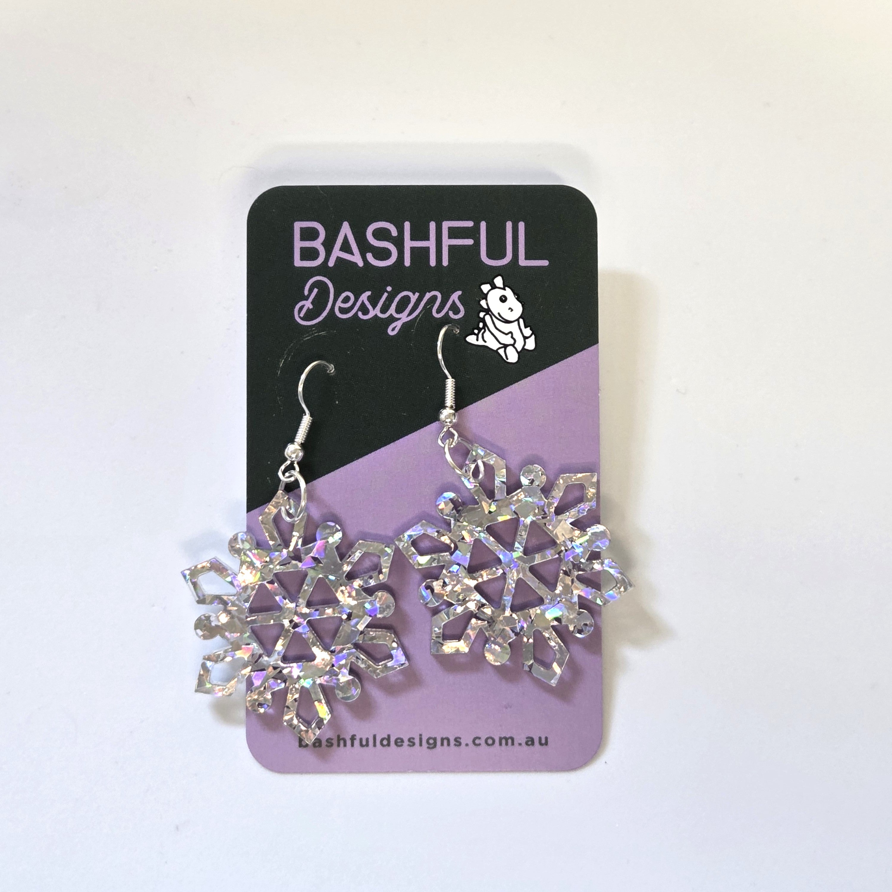 Earrings in the shape of a snowflake, made from silver holographic acrylic. 